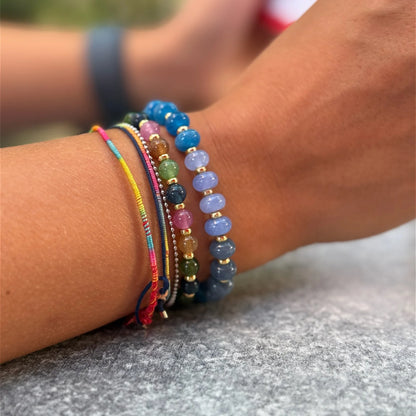 Colorful glass and jade bead bracelets worn together