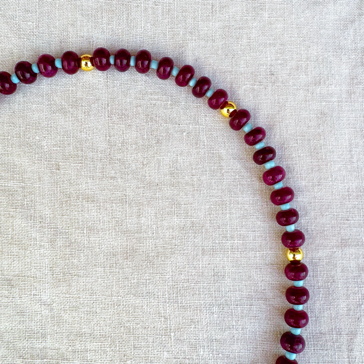 Detail view of Violetta necklace with burgundy and turquoise-coloured beads