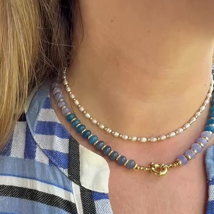 Blue jade and freshwater pearl necklaces worn layered together