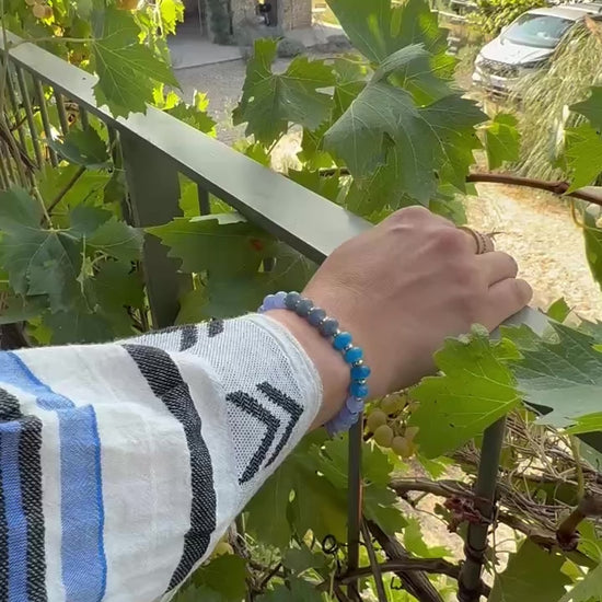 Blue jade bead bracelet worn on wrist